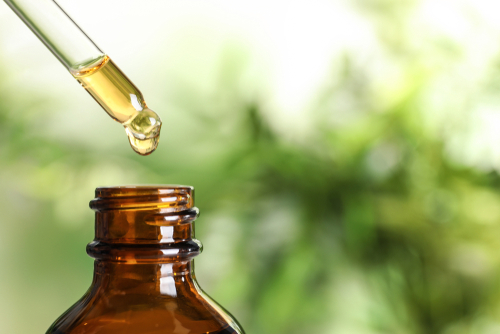 Dripping,Natural,Tea,Tree,Essential,Oil,Into,Bottle,On,Blurred