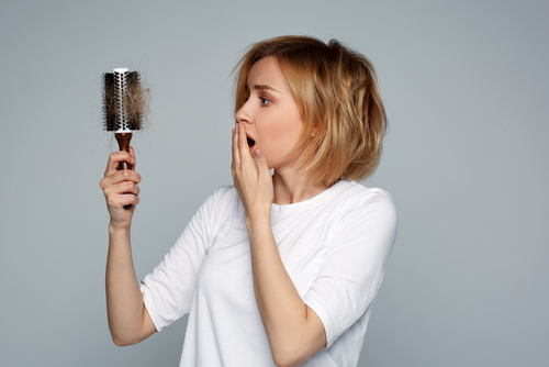 Blonde,Young,Worried,Woman,Holding,Hairbrush,With,Unexpected,Hair,Loss
