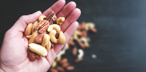 Hand,Full,Of,Mixed,Nuts,Over,More,Nuts,In,The