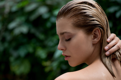 Beautiful,Young,Woman,Applies,A,Balm,,Shampoo,Or,Conditioner,To