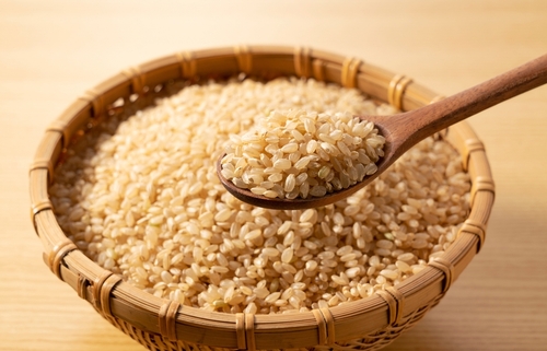 Brown,Rice,In,A,Bamboo,Colander,And,A,Wooden,Spoon
