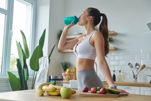 Beautiful,Young,Woman,In,Sports,Clothing,Drinking,Protein,Cocktail,While
