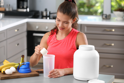 Woman,Preparing,Protein,Shake,In,Kitchen