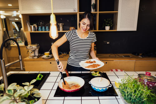 Smiling,Woman,Cooking,A,Healthy,Meal,In,Home,Kitchen.making,Dinner