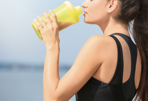 Beautiful,Young,Woman,Drinking,Protein,Shake,On,River,Bank