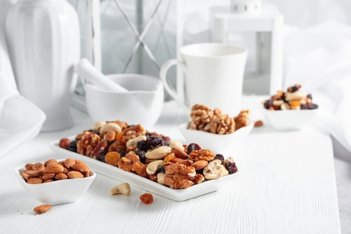 Mix,Of,Nuts,And,Raisins,On,A,White,Wooden,Table.