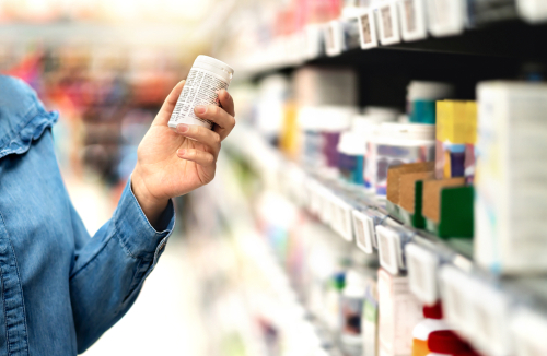 Customer,In,Pharmacy,Holding,Medicine,Bottle.,Woman,Reading,The,Label
