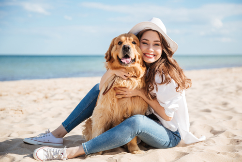 Cheerful,Pretty,Young,Woman,In,Hat,Sitting,And,Hugging,Her