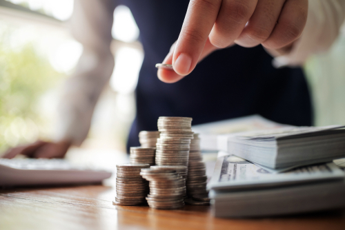 Business,Women,Put,Coin,Stack,Money,And,Many,Bank,Note