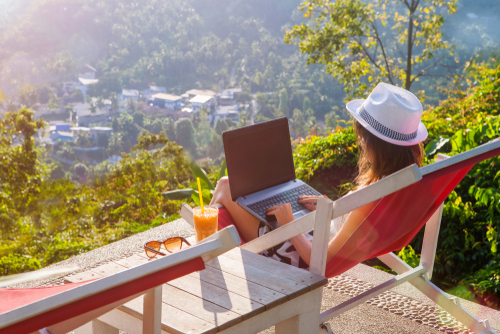 Girl,Freelancer,Work,Typing,On,Laptop,And,Looking,At,Monitor