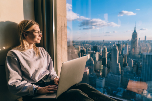 Caucasian,Female,Digital,Nomad,Sitting,With,Laptop,Computer,On,Window