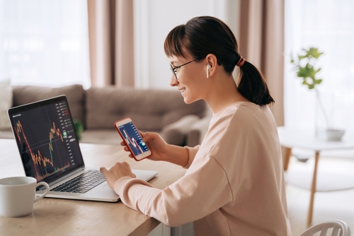 Smiling,Business,Woman,Trader,Analyst,Looking,At,Laptop,Monitor,,Holding