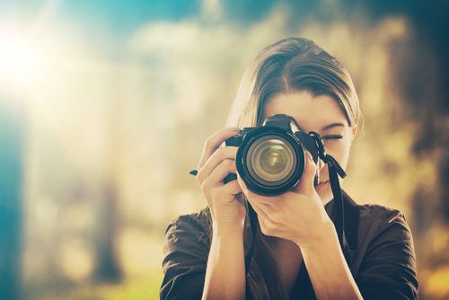 Portrait,Of,A,Photographer,Covering,Her,Face,With,The,Camera.