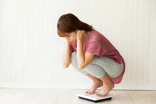 Young,Woman,Riding,A,Weight,Scale.